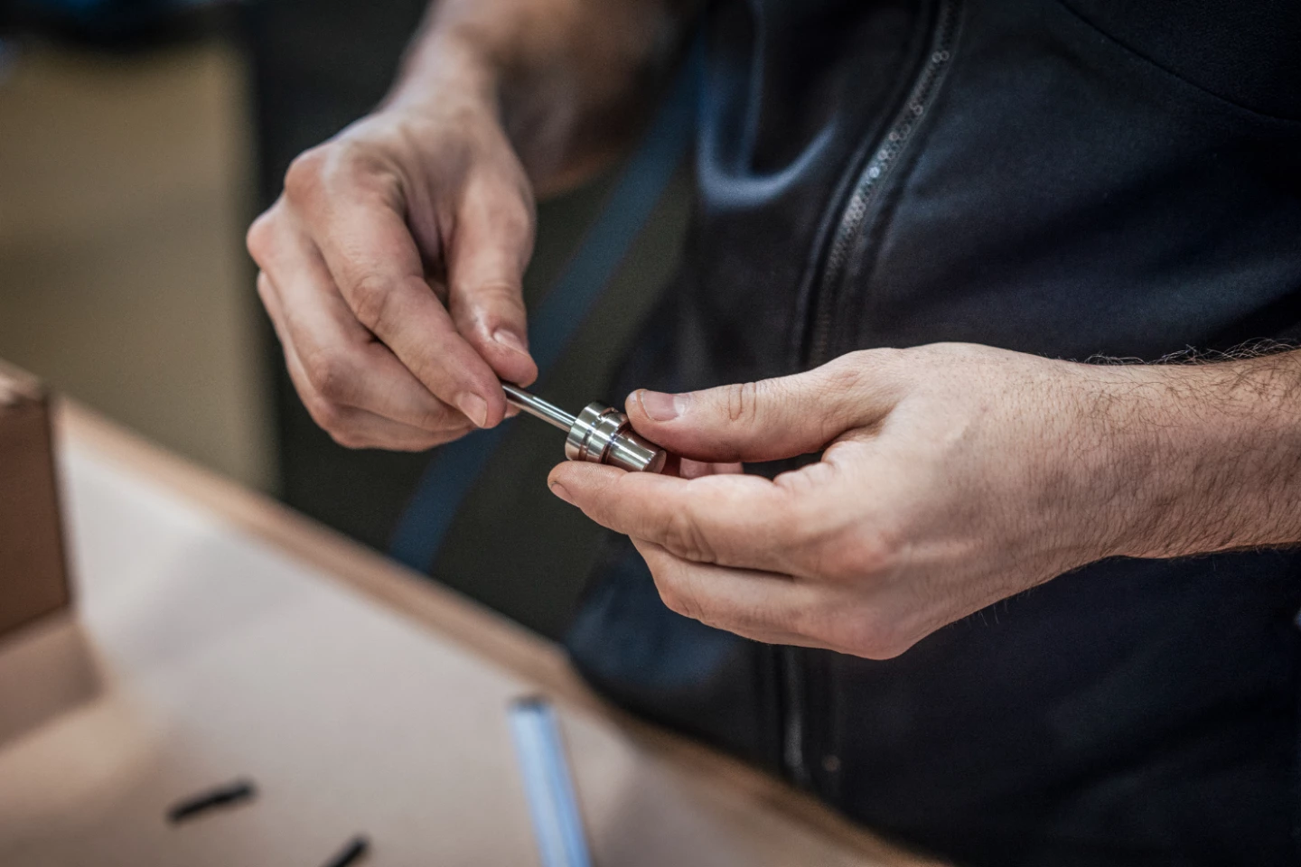 Mitarbeiter montiert eine Baugruppe von Hand und prüft ein feinmechanisches Präzisionsteil in der Produktion von hepro production ag.
