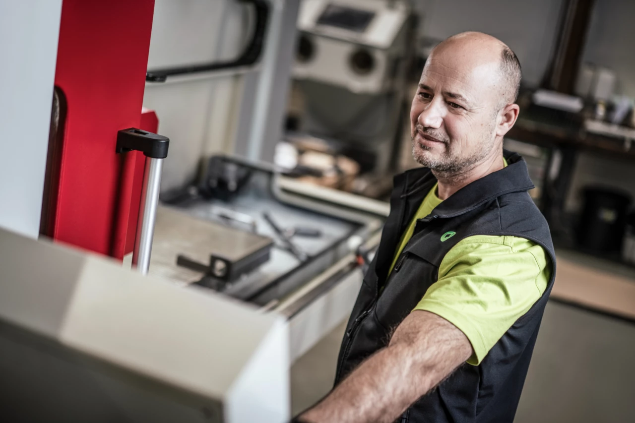 Mitarbeiter bedient eine CNC-Maschine über das Bedienpanel in der Produktion von hepro production ag.