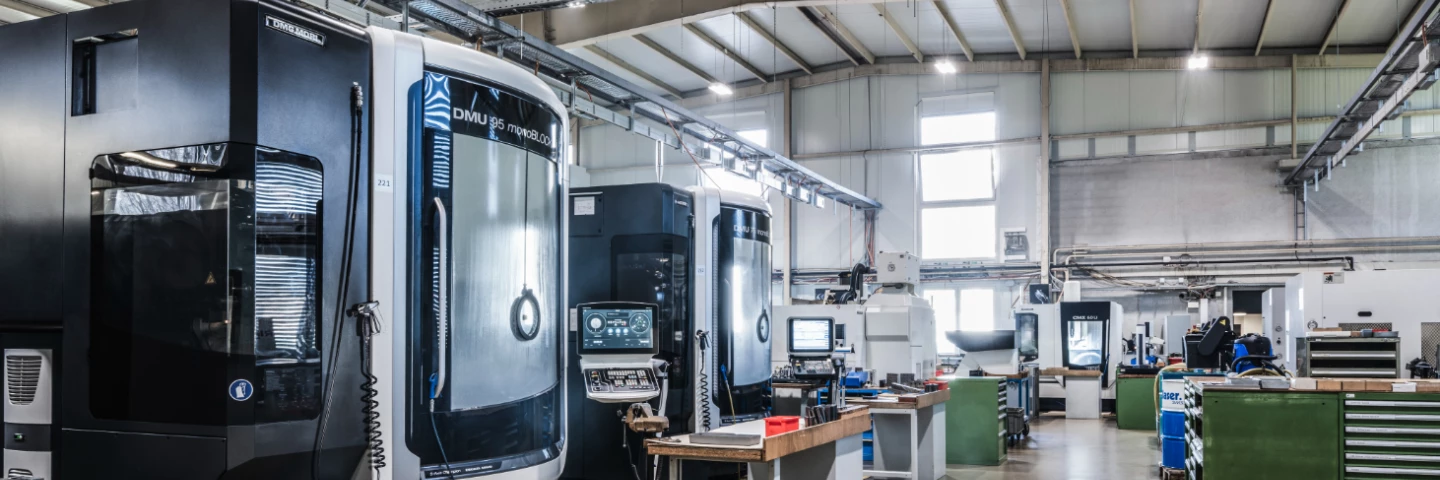 Blick in die Produktionshalle von hepro production ag mit mehreren CNC-Bearbeitungszentren, aufgeräumten Arbeitsplätzen und moderner Fertigungsinfrastruktur.