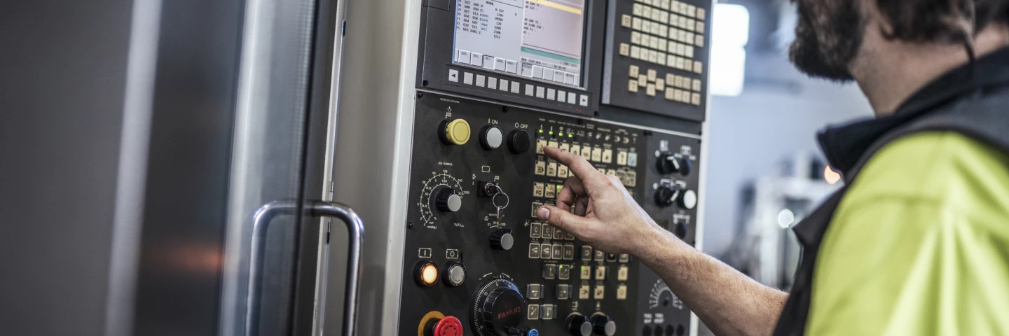 Mitarbeiter richtet ein Präzisionsbauteil in einem CNC-Maschinen-Spannsystem aus und befestigt es für die weitere Bearbeitung in der Fertigung von hepro production ag.