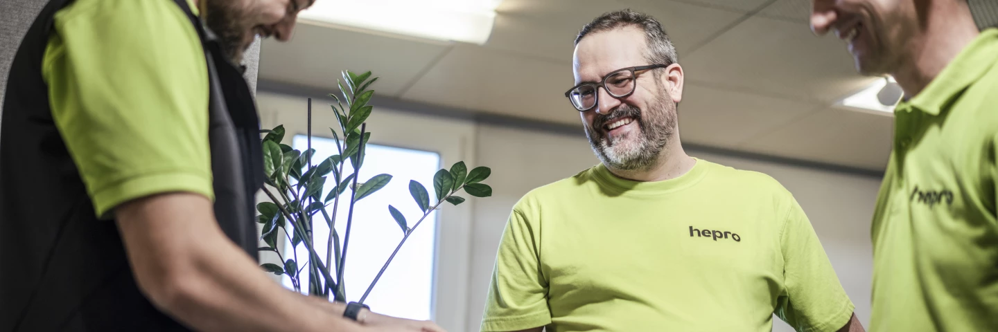 Drei Mitarbeitende von hepro production ag besprechen gemeinsam eine technische Lösung am Arbeitsplatz und tauschen sich kollegial über ein Projekt aus.