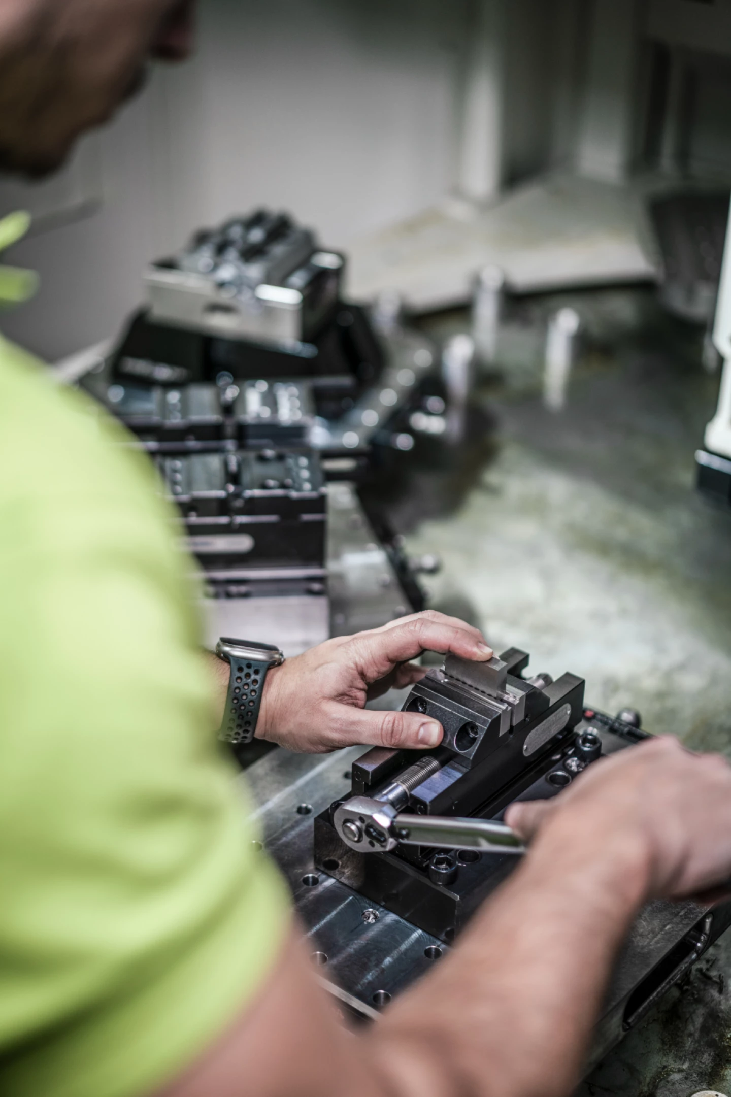 Mitarbeiter richtet ein Präzisionsbauteil in einer CNC-Maschine aus und befestigt es mithilfe eines Spannsystems in der Fertigung bei hepro production ag.