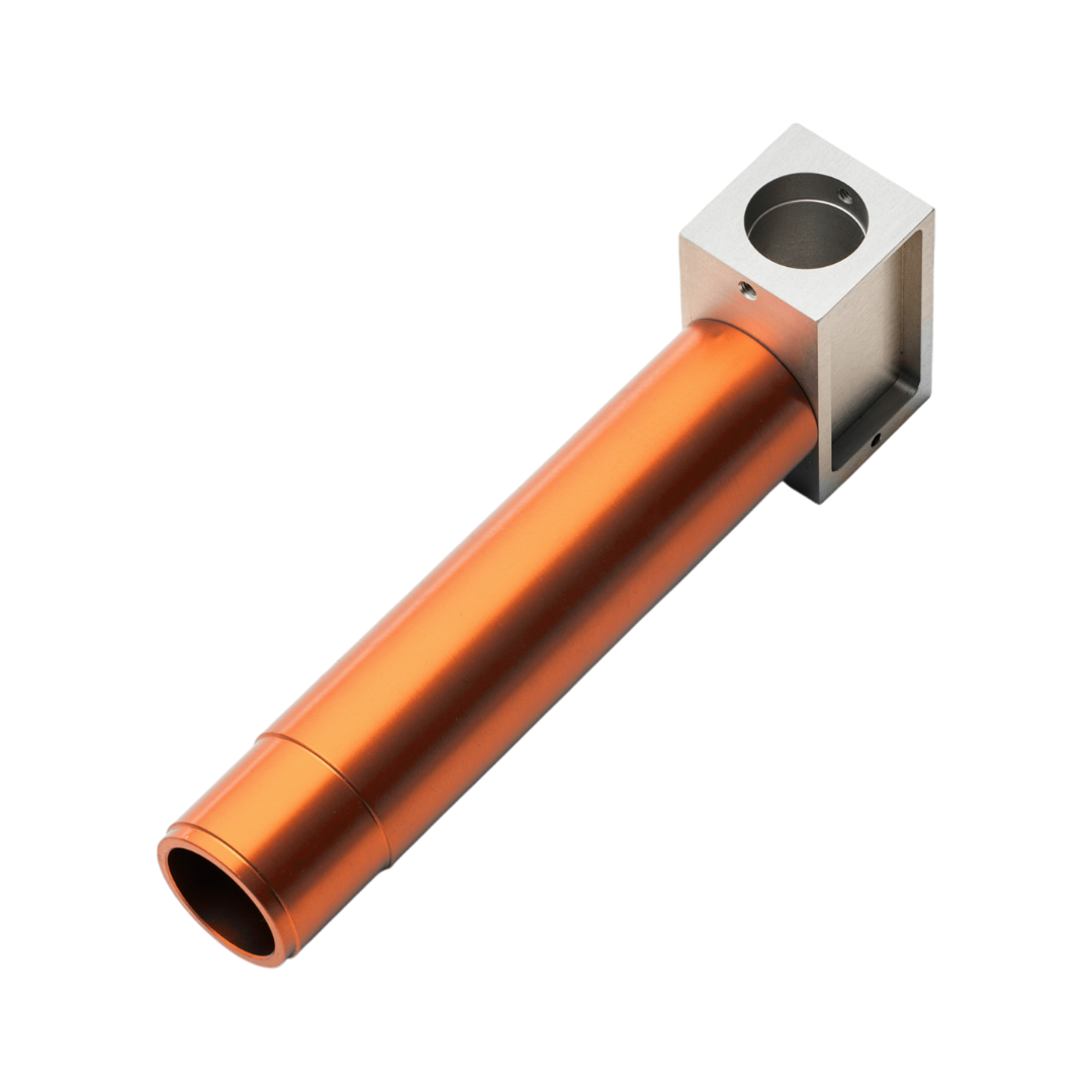 Freigestelltes, CNC-gefertigtes Präzisionsbauteil aus Kupfer und Aluminium von hepro production ag mit zylindrischem Rohrkörper, integrierter Aufnahme und sauber bearbeiteten Bohrungen.