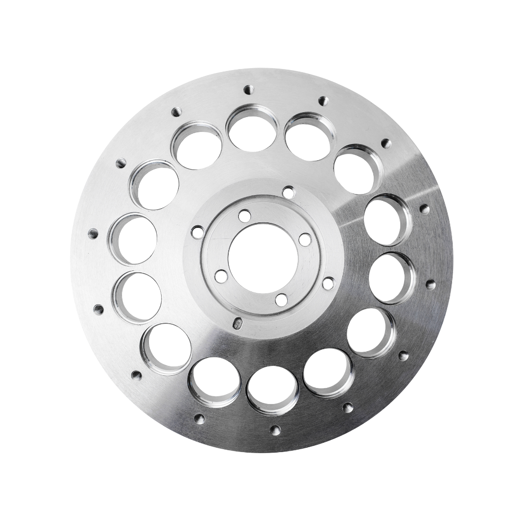 Freigestelltes Foto einer runden, silbernen CNC-gefrästen Metallplatte mit zentraler Öffnung, kleinem Schraublochkreis und mehreren großen, gleichmäßig verteilten Durchbrüchen; schwarzer Hintergrund.